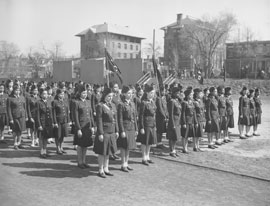 Photo of school kids in military uniforms in formation, prepared to perform military drills.