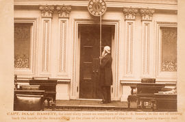 Capt. Isaac Bassett, for over sixty years an employee of the U. S. Senate, in the act of turning back the hands of the Senate clock at the close of a session of Congress. (Acc. No. 38.00502.001)