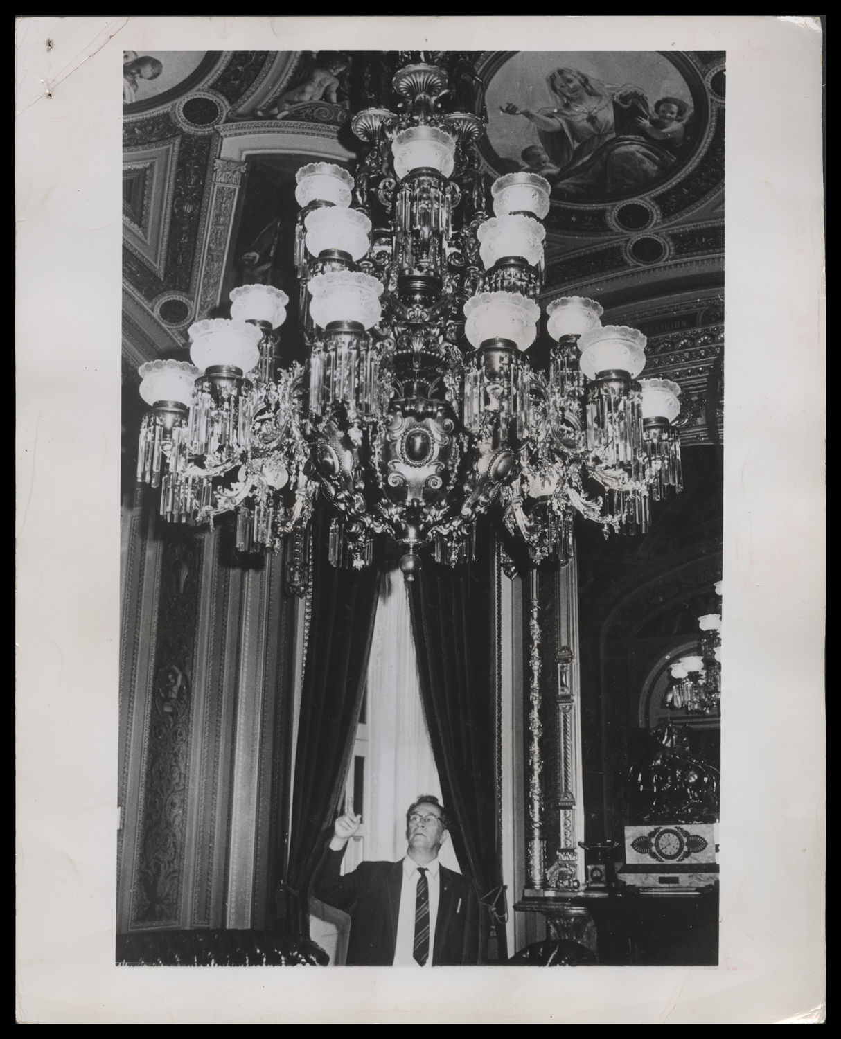 Lawrence Laser, Now the Capitol's Assistant Electrical Engineer, Points to the Oldest Chandelier (Acc. No. 38.01270.001)