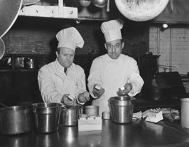 Photo of two chefs preparing food.