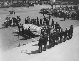Photo of senator accepting U.S. flag from military escort in front of Capitol Building.