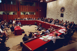 John Roberts being questioned by senators in a crowded hearing room.
