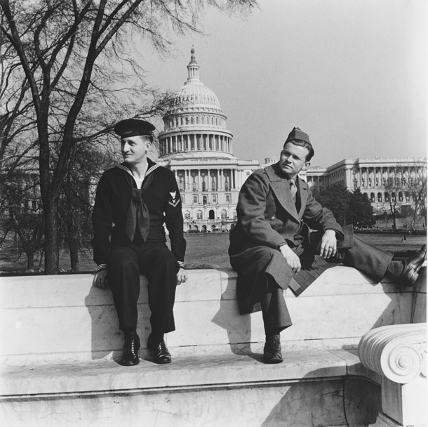 Photo of two servicemen resting in front of the U.S. Capitol Building