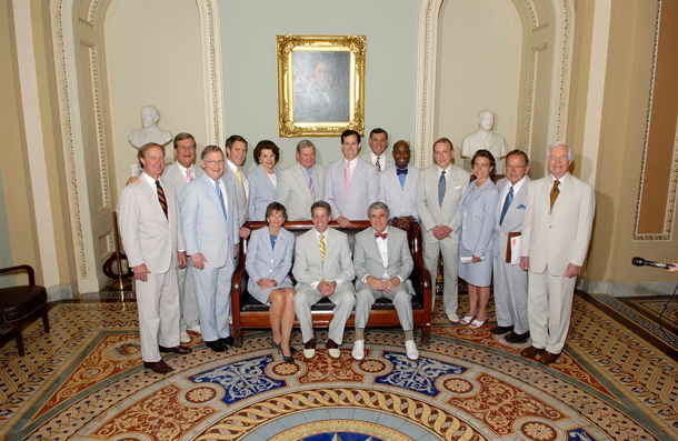 Sixteen U.S. senators pose in a hallway in light-colored seersucker suits, instead of doing something for the American people.