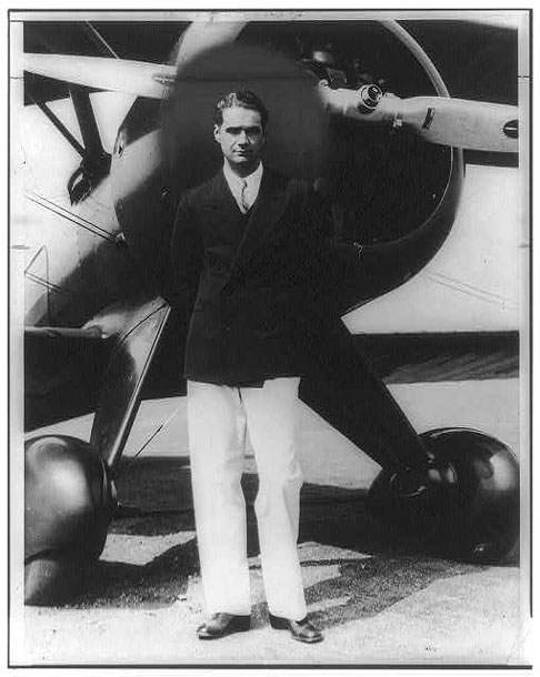 Howard Hughes standing in front of his new Boeing Army Pursuit plane.